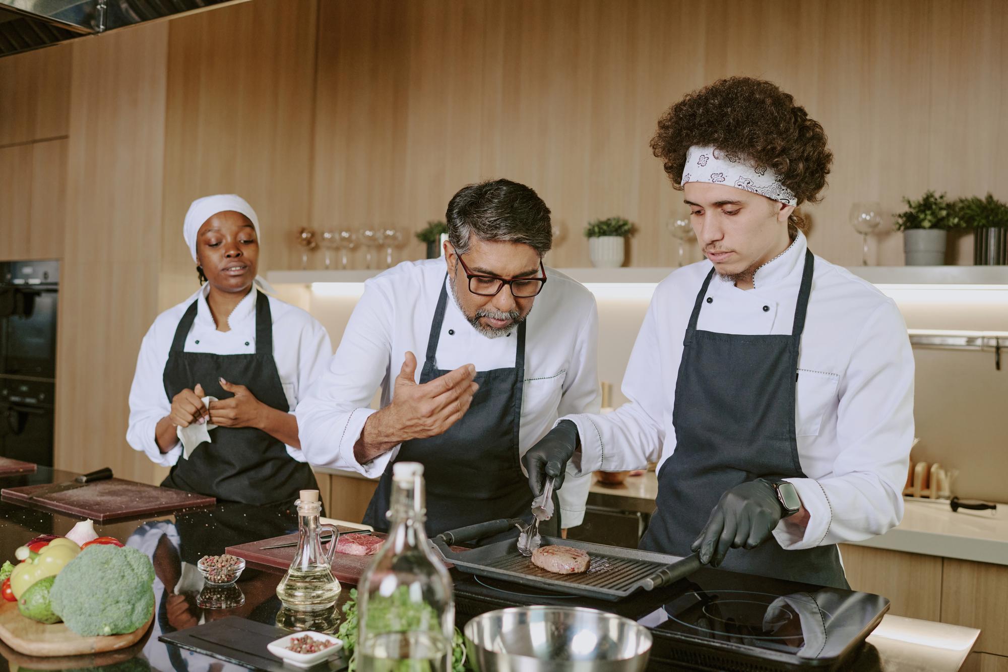 Chef teaching small group in professional kitchen
